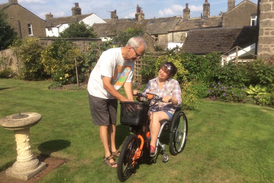 man and woman in a Motorised wheelchair basket