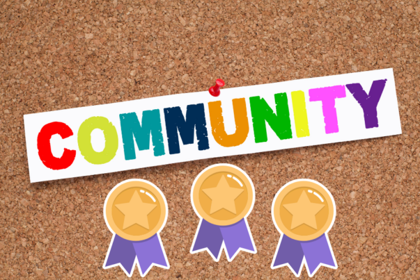 Community note with different coloured letters, pinned on horizontal cork board. Under the letters there are three award stickers.