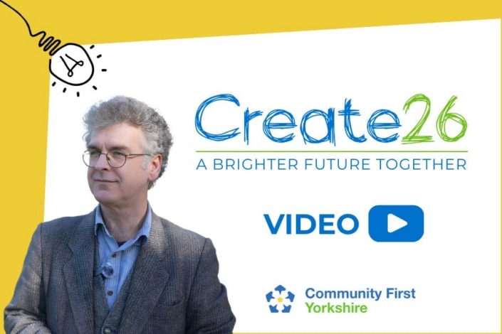 A man in a grey jacket stands before a white background with the text Create26: A Brighter Future Together, a video play button for the new video, and the Community First Yorkshire logo. A lightbulb graphic decorates the top corner, symbolising lasting impact.