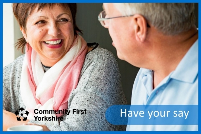 A woman and a man sit together smiling and talking. The words Community First Yorkshire and Have your say are displayed, suggesting a friendly discussion about organisation matters like community involvement or mileage cost changes.